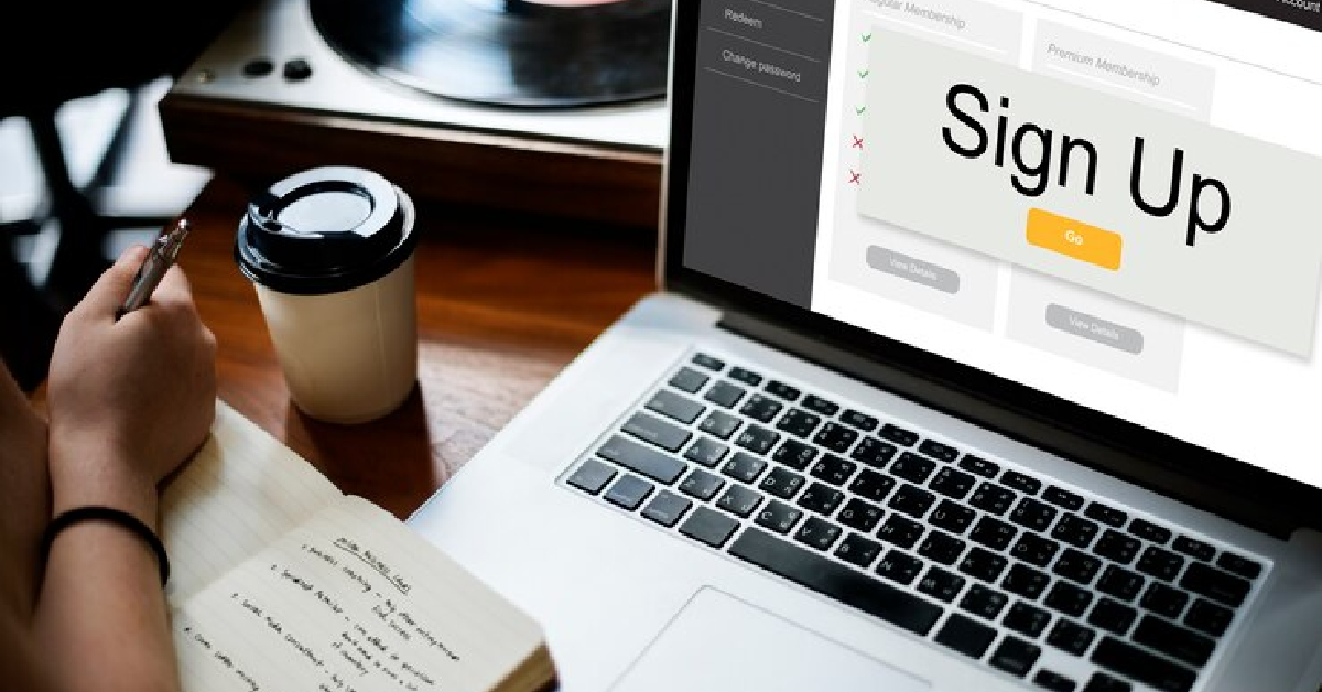 A person sitting at a desk with a laptop, using an Event Management System to enhance the attendee's experience.
