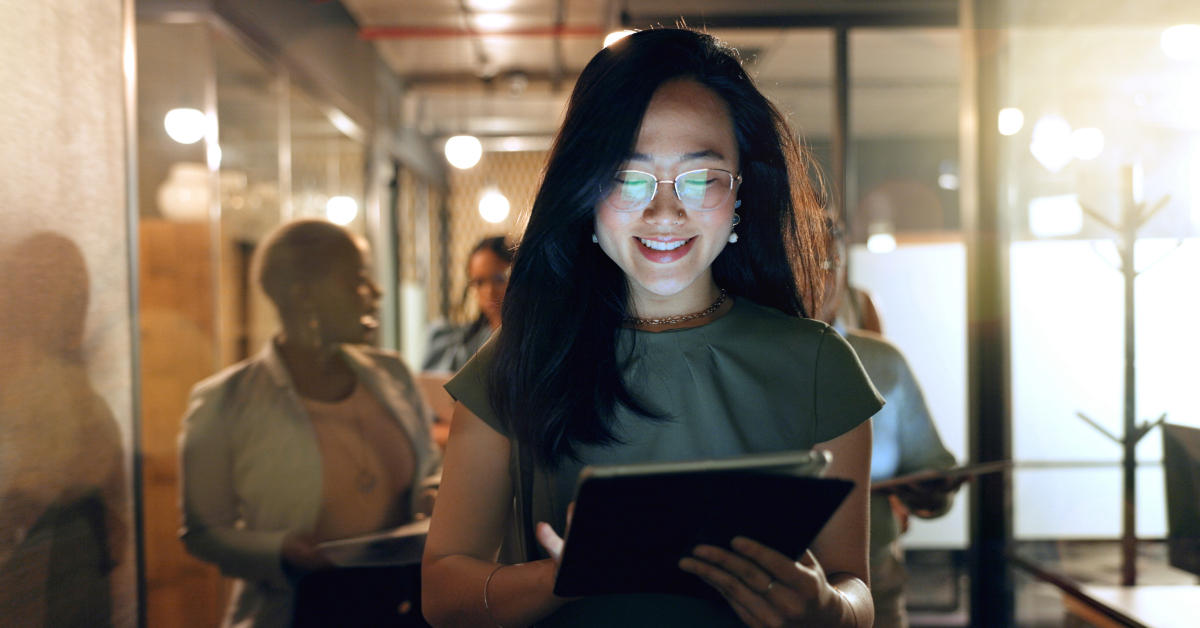 Asian business woman holding a tablet in an office engaged in modern business communication.