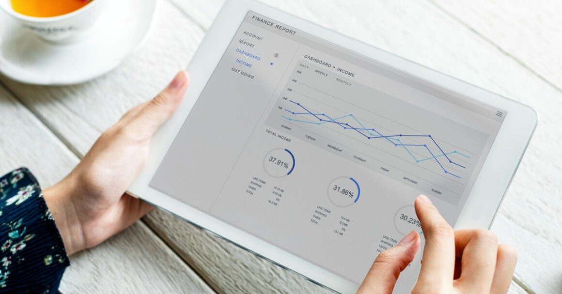 человек держит планшет с финансовым графиком и кофейную чашку