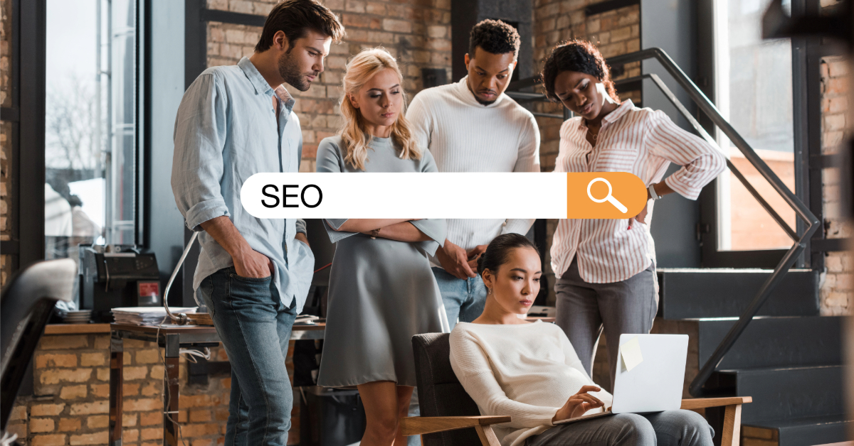 Five people are gathered around a seated woman in an office setting, intently discussing strategies displayed on her laptop. A search bar with "Hiring SEO Expert in Singapore" overlays the image, highlighting their quest to enhance digital presence and expertise.