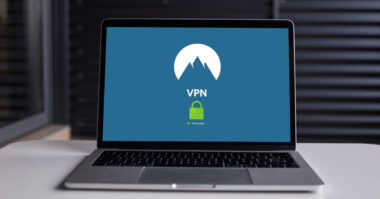 A laptop displays a VPN screen with a mountain logo and a green padlock icon, ensuring your web experience remains protected and private.