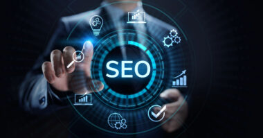 A person in a suit touches a virtual screen with "SEO" at the center, surrounded by icons representing graphs, gears, and a magnifying glass—ideal for boosting ecommerce strategies through platforms like Shopify.