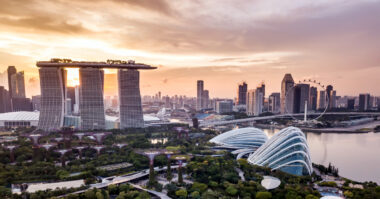 Aerial view of Singapore at sunset, featuring Marina Bay Sands, Gardens by the Bay, the Singapore Flyer, and downtown skyscrapers—an inspiring backdrop for those considering affordable business registration in this vibrant city.