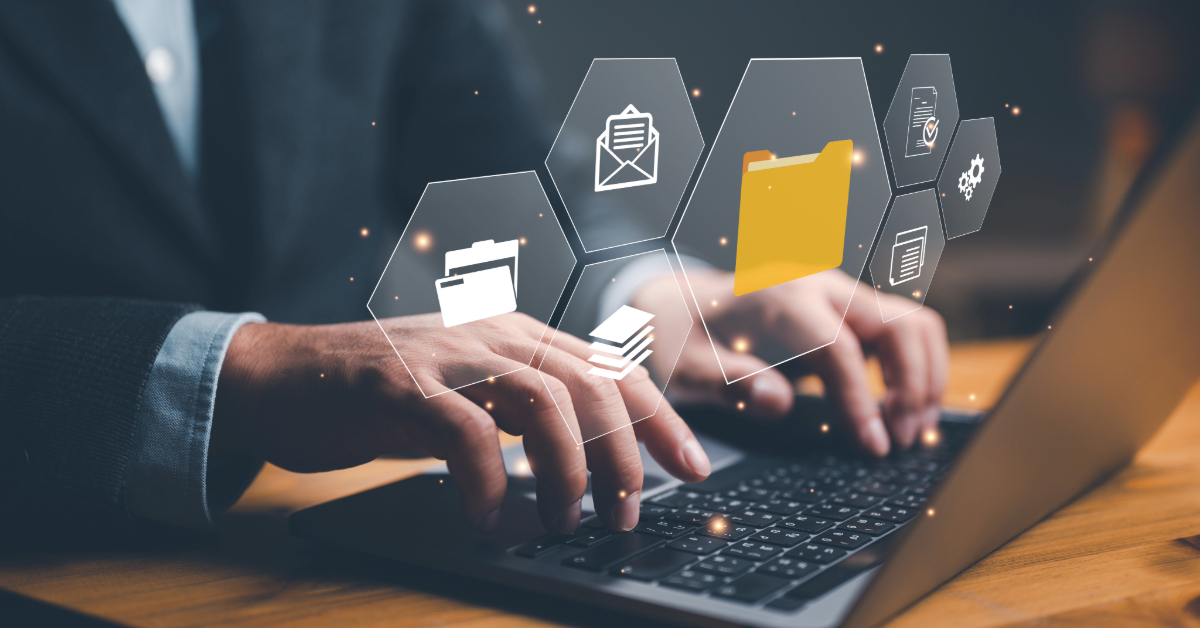 Hands typing on a laptop keyboard with floating digital icons of a folder, mail, and documents above, illustrating the seamless integration of Regular Active Directory Assessments to ensure optimal network health.