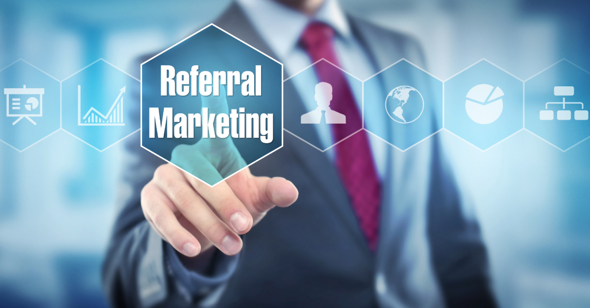 A person in a suit touches a transparent digital screen displaying hexagonal icons. The main icon reads "Referral Marketing," showcasing effective referral strategies that leverage the network effect to amplify outreach and engagement.