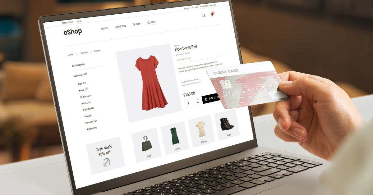 A person holds a credit card while shopping online for a red dress on their laptop, which displays an eCommerce store.