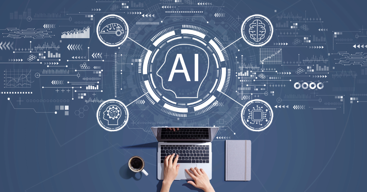 A person types on a laptop with a coffee cup and notebook nearby; a digital graphic featuring "AI" and technology icons highlights the role of artificial intelligence in business above the workspace.