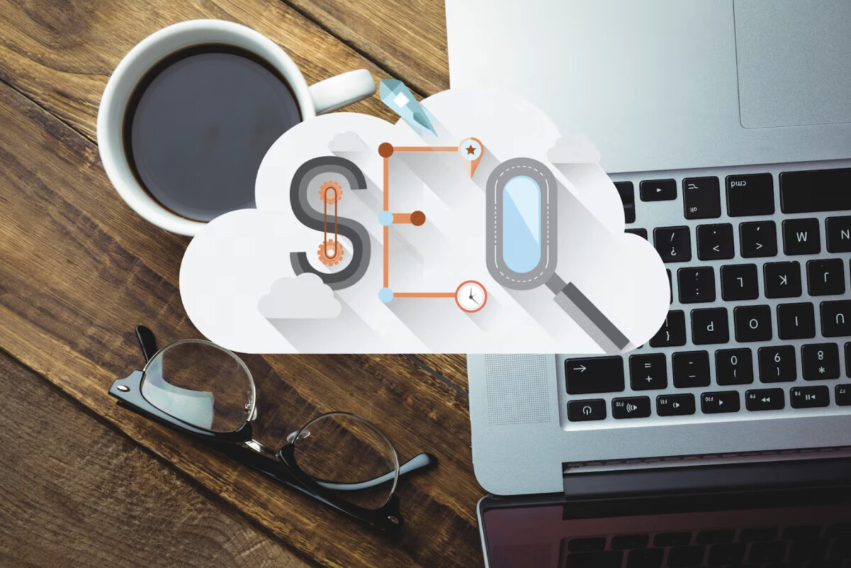 A cup of coffee, a pair of eyeglasses, and a laptop on a wooden desk with an SEO graphic overlayed in the center, highlighting Business Presence and effective SEO Marketing Strategies.