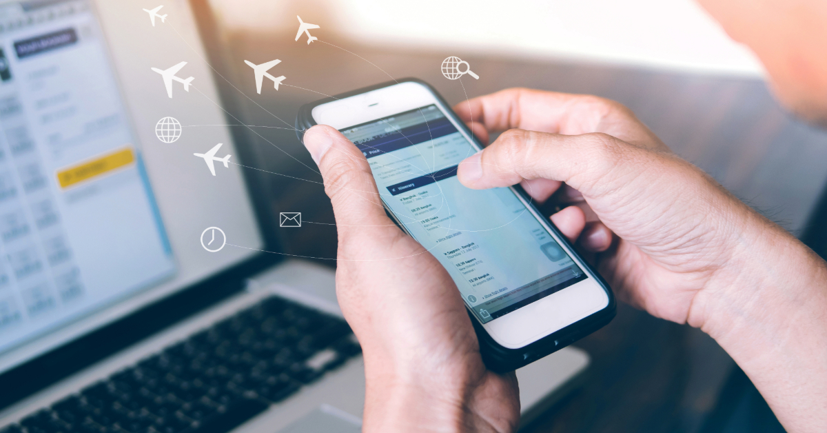 A person uses a smartphone to check flight information, with a laptop in the background and travel-related icons digitally overlaid, integrating features like online booking for a seamless travel planning experience.