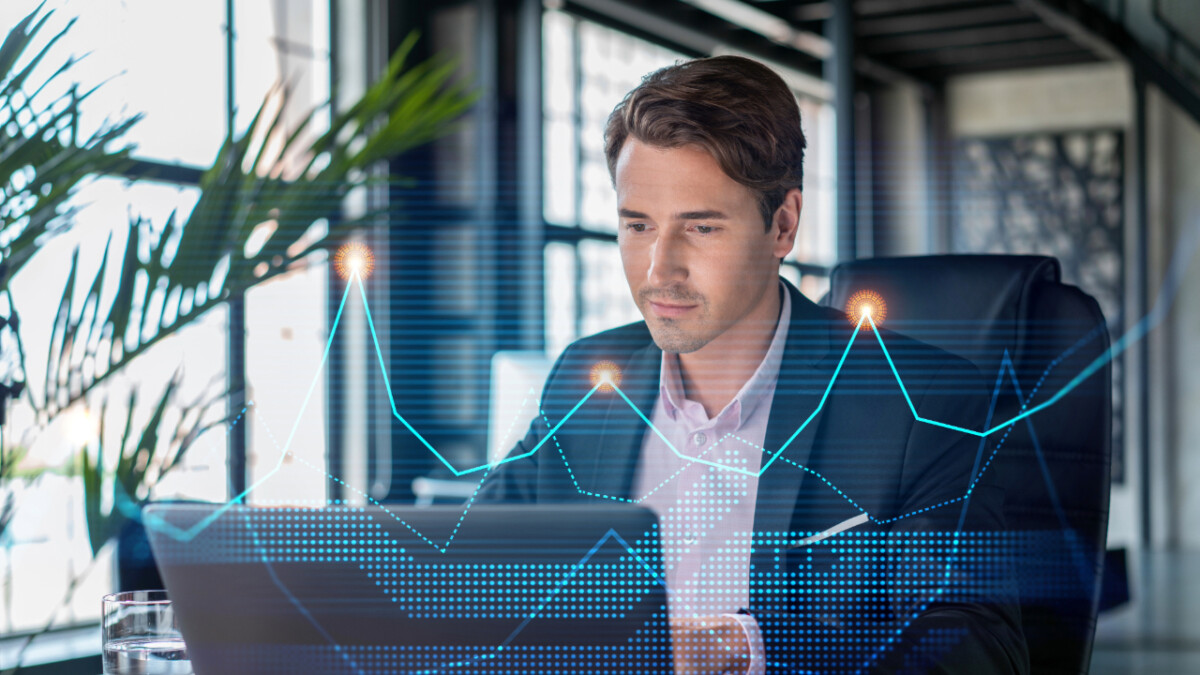 A man in business attire works on a laptop in an office, with digital financial graphs and data visualizations highlighting advanced forex back office software features in the foreground.