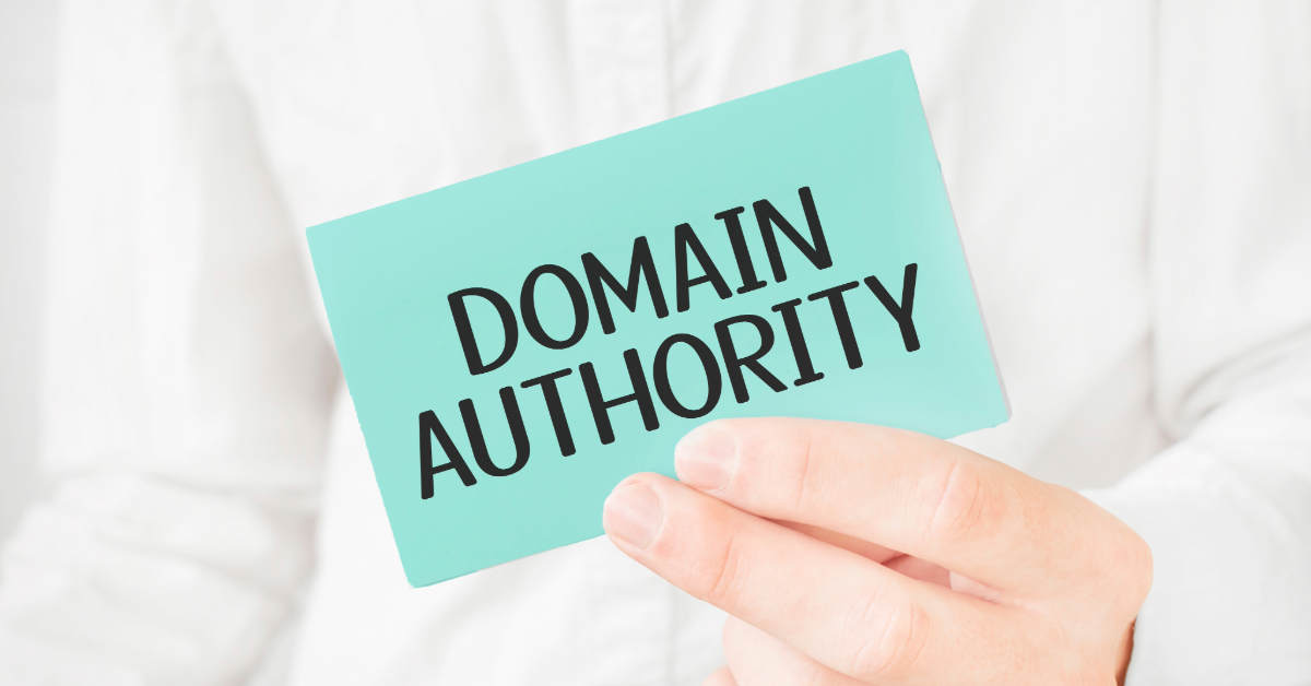 A person holding a blue card with the words "DOMAIN AUTHORITY" printed in bold black letters, highlighting the importance of SEO to boost Domain Authority.
