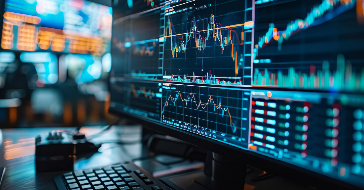 Multiple computer monitors display financial charts, stock graphs, and data from CryptoRobotics in a busy crypto trading environment, with a keyboard in the foreground.