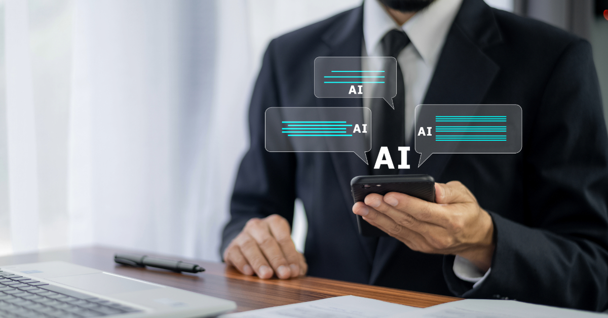 A man in a suit sits at a desk using a smartphone, with illustrated AI chat bubbles—showcasing how Natural Language Processing is transforming customer experience—appearing above the device.