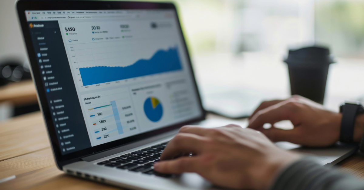 A person working on a laptop displaying data analytics dashboards with charts and graphs—a scene familiar to small businesses and SEO agencies; a coffee cup sits in the background.