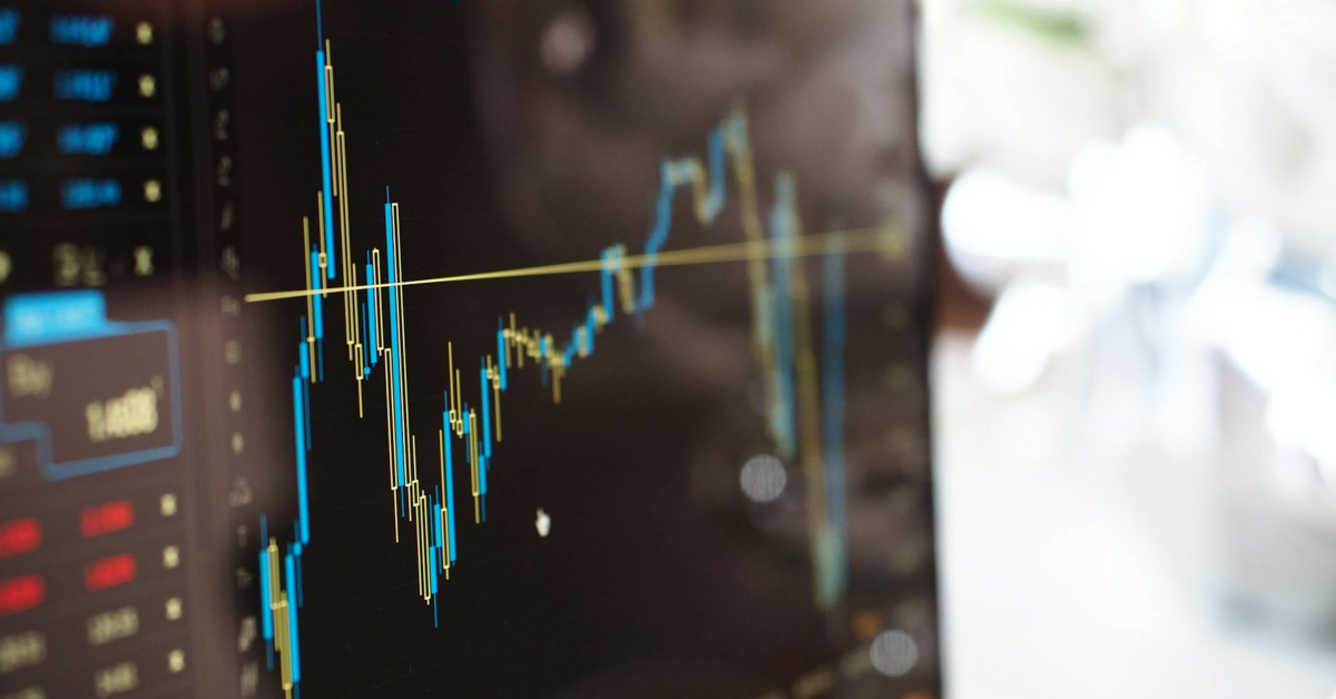 A close-up of a computer screen displaying a candlestick stock chart with a yellow trend line and data on the side, highlighting ecommerce profits and smart ways to invest.