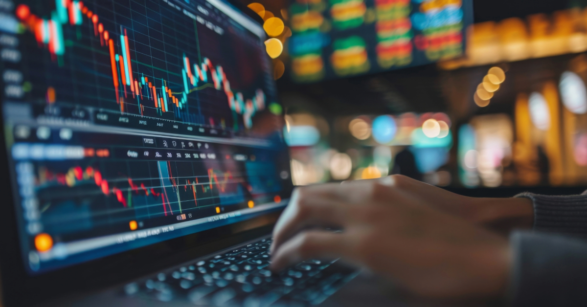 A person uses a laptop displaying stock market charts and graphs, with blurred financial data screens in the background, analyzing liquidity trends and seeking insights from top Liquidity Providers.