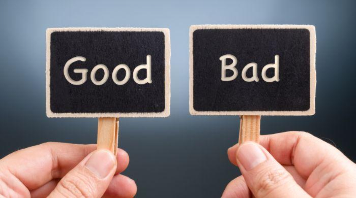 Two hands hold up small signs—one reads "Good" and the other "Bad," both on black backgrounds with white text—symbolizing how your credit score can be affected, good or bad, by choices like using payday loans.