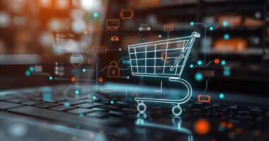 A digital shopping cart icon is displayed over a laptop keyboard, with floating tech and security symbols illustrating how AI for eCommerce can enhance security and protect online shopping from emerging threats.